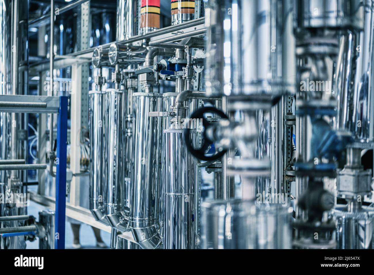 Grand tube avec petite vanne noire à l'usine de production Banque D'Images