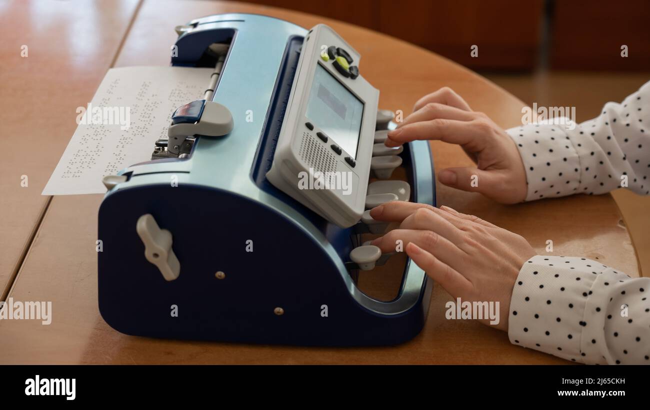 Femme aveugle utilisant une machine à écrire en braille. Banque D'Images
