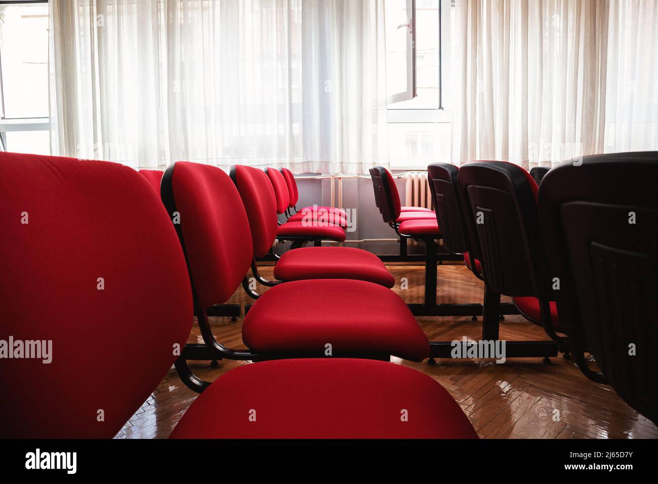 Intérieur d'une salle de classe avec chaises rouges. Banque D'Images