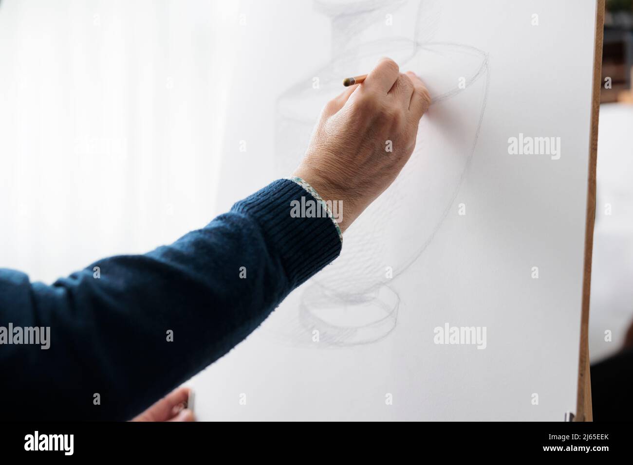 Gros plan du modèle de vase de dessin d'enseignant senior sur toile blanche à l'aide d'un crayon d'esquisse d'illustration pendant la classe d'art dans l'atelier créatif. Artiste esquissant une œuvre développant une technique graphique Banque D'Images