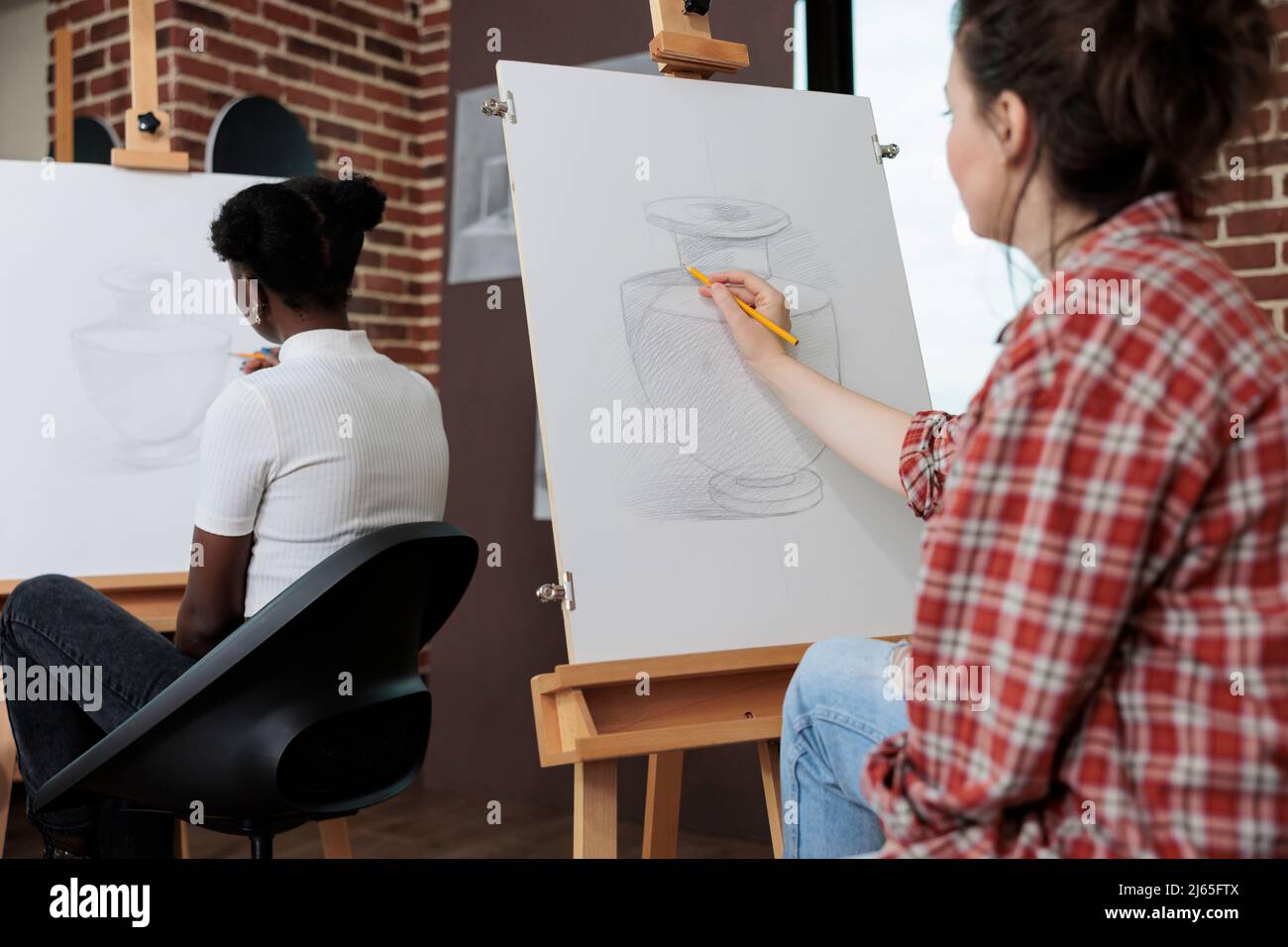 Jeune étudiant dessin vase artistique sur toile de peinture travailler à la technique d'illustration en utilisant le crayon graphique pendant la leçon d'art en studio de créativité. Équipe multiethnique développant des compétences créatives Banque D'Images