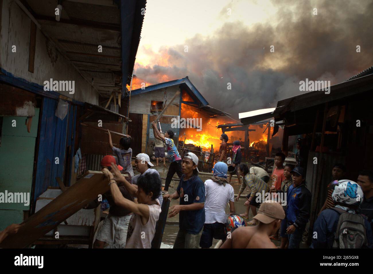 Les résidents qui tentent de faire descendre des maisons pour éviter que l'incendie ne se propage en cas d'incendie, brûlent un quartier dense de Penjaringan, dans le nord de Jakarta, à Jakarta, en Indonésie. En dix ans (2011-2020), 269 habitants de la ville ont perdu la vie en raison d'accidents d'incendie, soit une moyenne de 26,9 morts par an. Il y a eu 164 cas de pompiers blessés pour des tâches d'extinction d'incendie. La vie d'un pompier a été perdue au cours de la même période. Banque D'Images