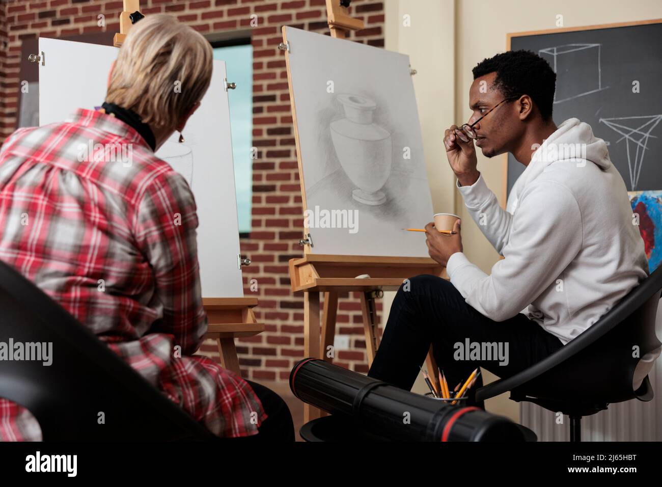 Professeur principal supervisant l'élève expliquant la technique d'illustration travaillant à l'art créatif pendant la leçon d'art. Homme dessin vase modèle sur toile à l'aide d'un crayon graphique. Résolutions du nouvel an Banque D'Images