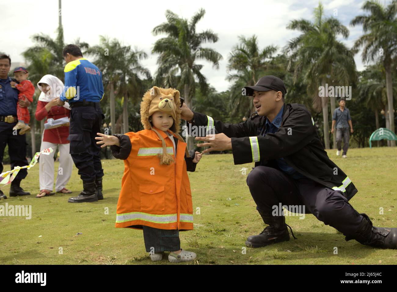 Un membre de l'équipe de lutte contre les incendies de Jakarta s'est amusé avec sa fille qui porte un uniforme de pompier après les cérémonies et les expositions pour célébrer la journée indonésienne de lutte contre les incendies et de sauvetage qui est commémorée le 1 mars chaque année, au Monument national du centre de Jakarta, Jakarta, Indonésie. Banque D'Images