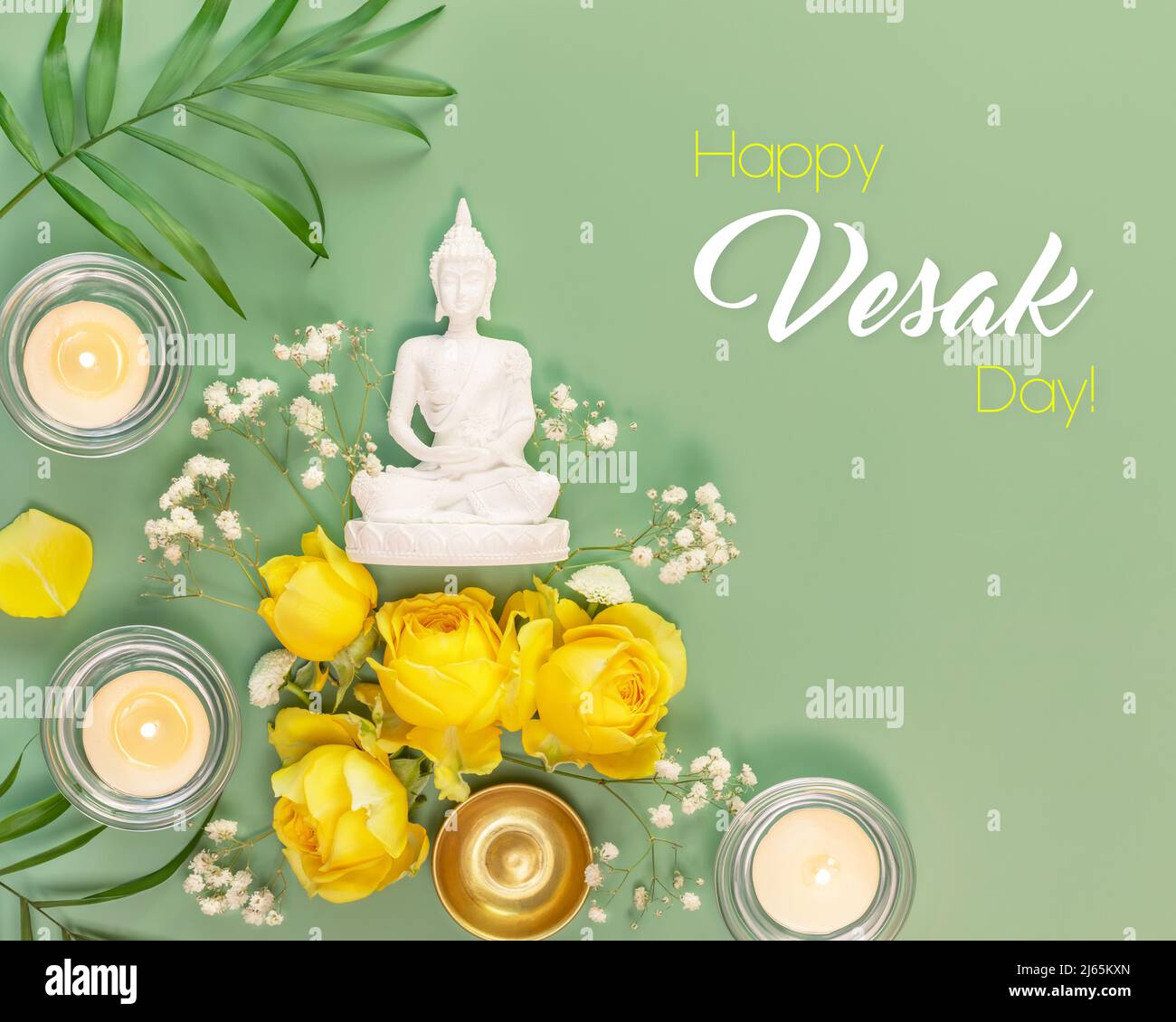 Vesak, Fête du Bouddha. Statue de Bouddha, roses jaunes, feuilles de palmier et bougies sur fond vert avec inscription de félicitations. Vacances asiatiques et budd Banque D'Images