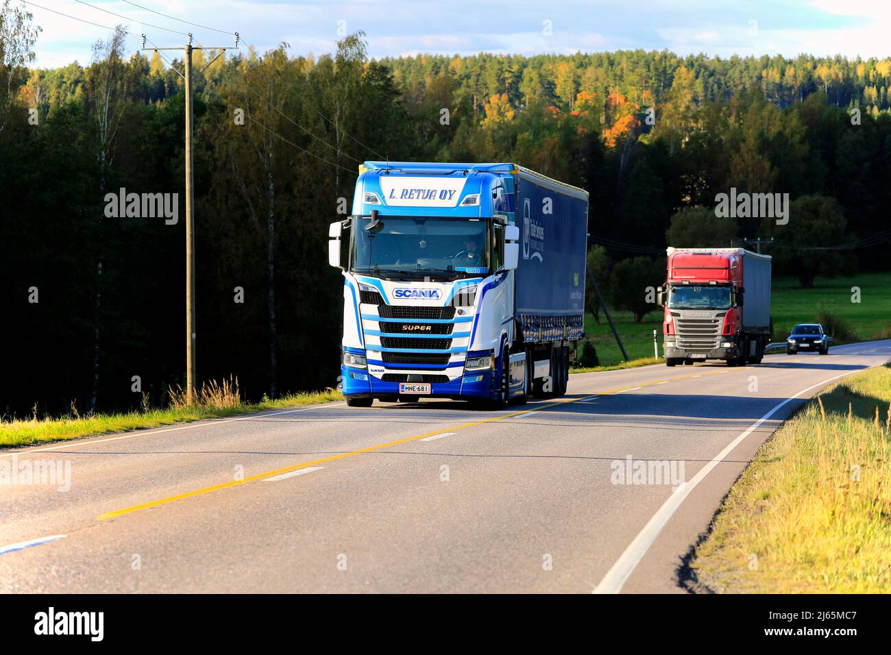 Le camion Scania S450 de L Retva Oy tire une semi-remorque suivie d'un autre camion sur l'autoroute 52 en plein soleil d'automne. Tenhola, Finlande. 27 septembre 2019. Banque D'Images