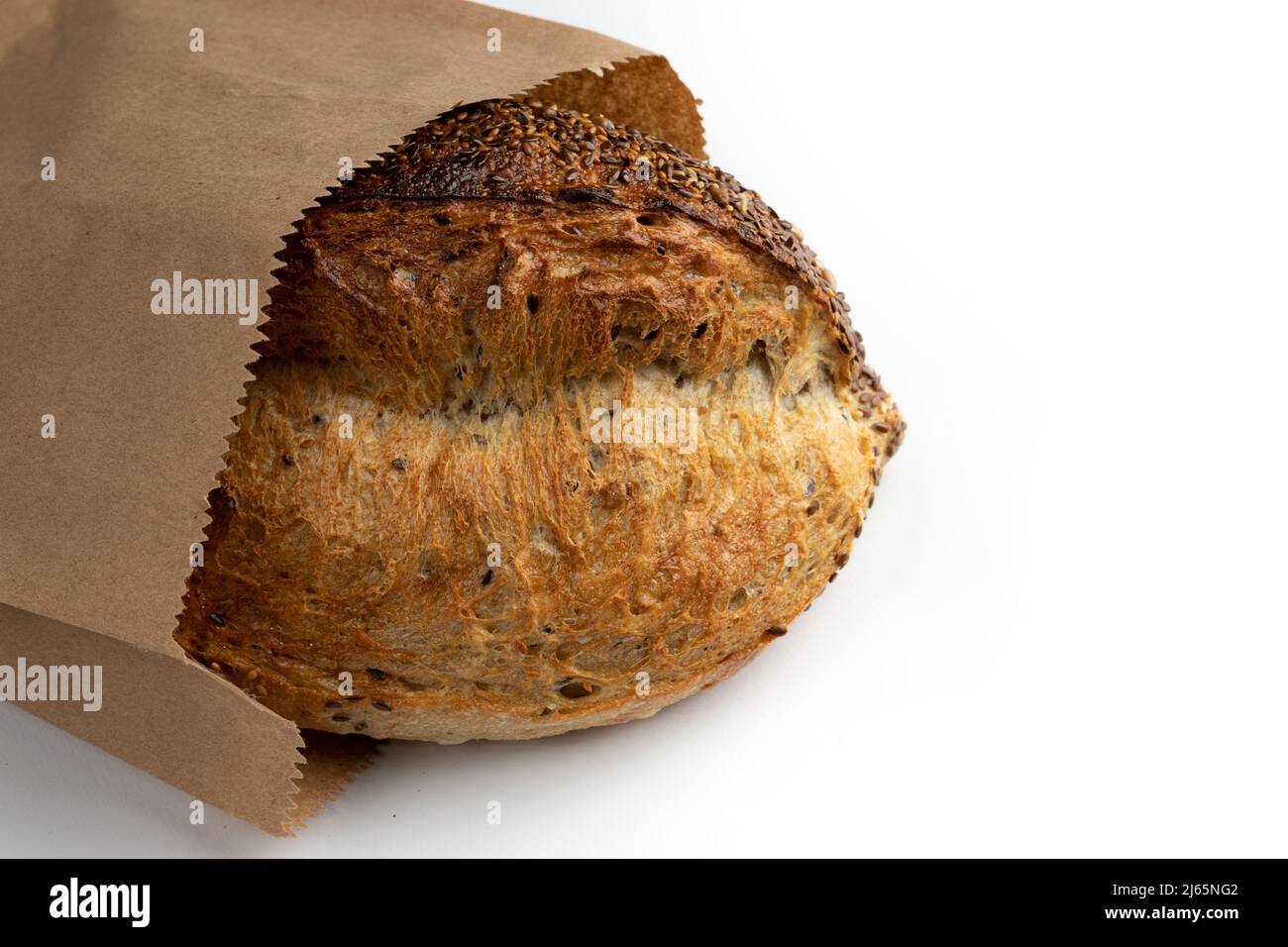 pain de blé doré isolé sur fond blanc, cuisson maison, pain de grain entier frais gros plan dans un sac de papier, vue latérale Banque D'Images