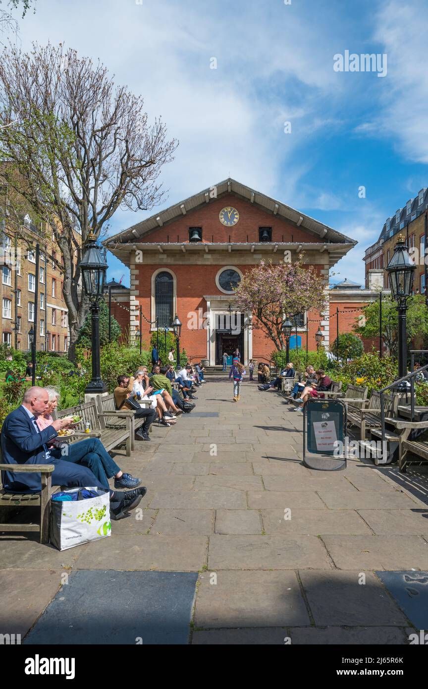 Les gens assis sur des bancs socialisent et se détendent dans le jardin de l'église St Paul à Covent Garden lors d'une journée ensoleillée de printemps. Londres, Angleterre, Royaume-Uni. Banque D'Images