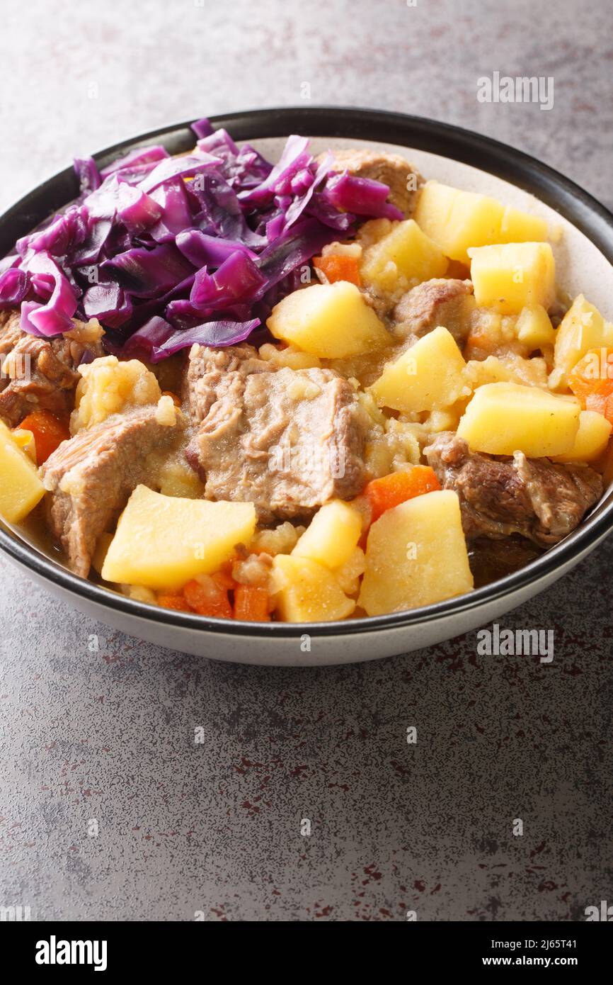 Le Scouse anglais est un ragoût de boeuf ou d'agneau avec des légumes dans la plaque sur la table. Verticale Banque D'Images