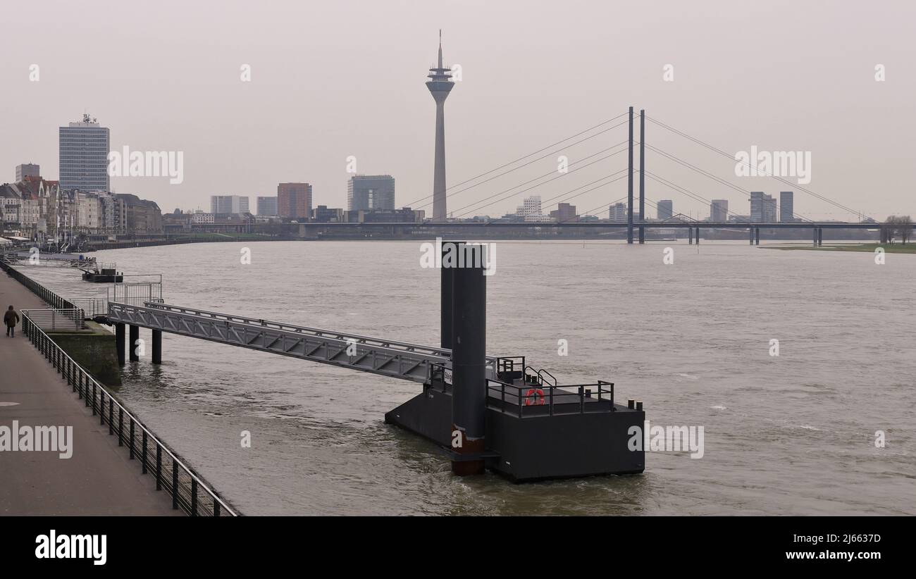 Rhin à Düsseldorf Allemagne, pont Oberkasseler avec vue sur la ligne d'horizon, une journée par temps nuageux, rive est avec promenade et jetée Banque D'Images