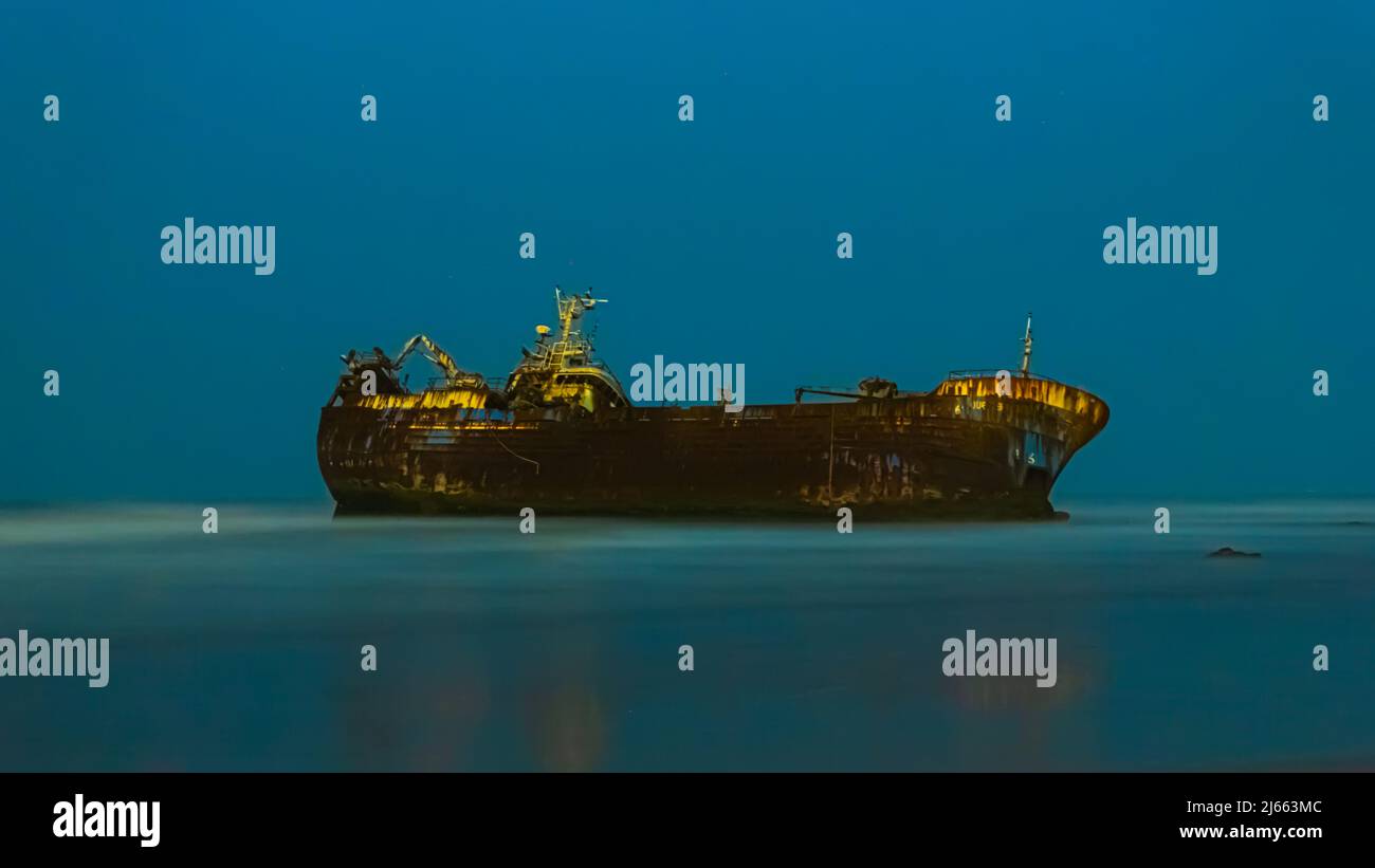 Vieux bateau coincé dans le sable d'une plage la nuit Banque D'Images Vieux bateau coincé dans le sable d'une plage la nuit Banque D'Images
