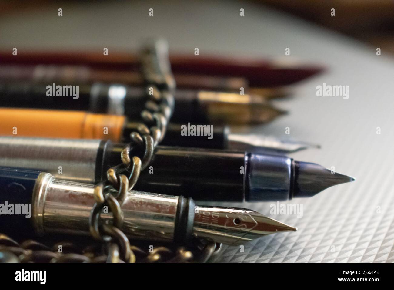 Peu de stylos enveloppés dans une chaîne en fer se trouvent sur la table. Concept- restriction de la liberté de parole. Banque D'Images