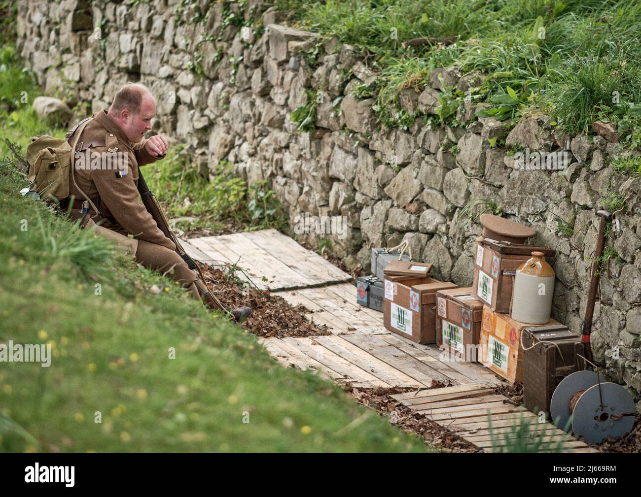 Un soldat réacteur du WW1 Essex Regiment repose sur une décharge de munitions de tranchée lors de l'événement No Man's Land à Bodrhyddan Hall, au pays de Galles Banque D'Images