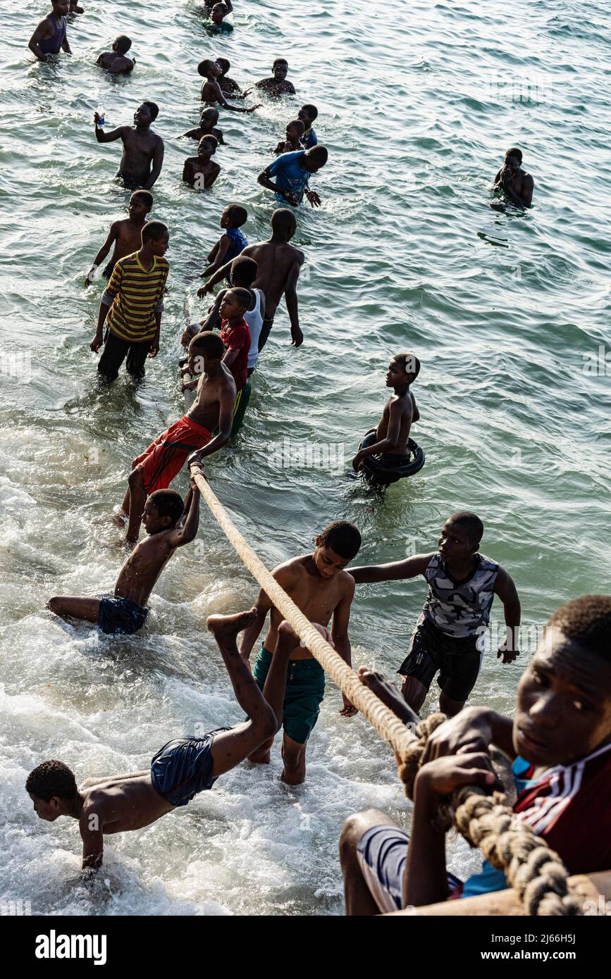 Jugendliche turnen an Seil am Stadtstrand, Stone Town, Altstadt, Unguja, Sansibar, Tansania Banque D'Images