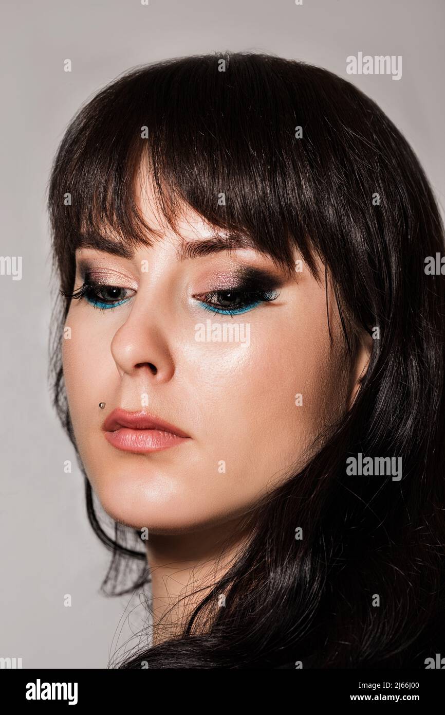 Jeune belle fille avec le maquillage abaissé ses yeux et regarde vers le bas Banque D'Images