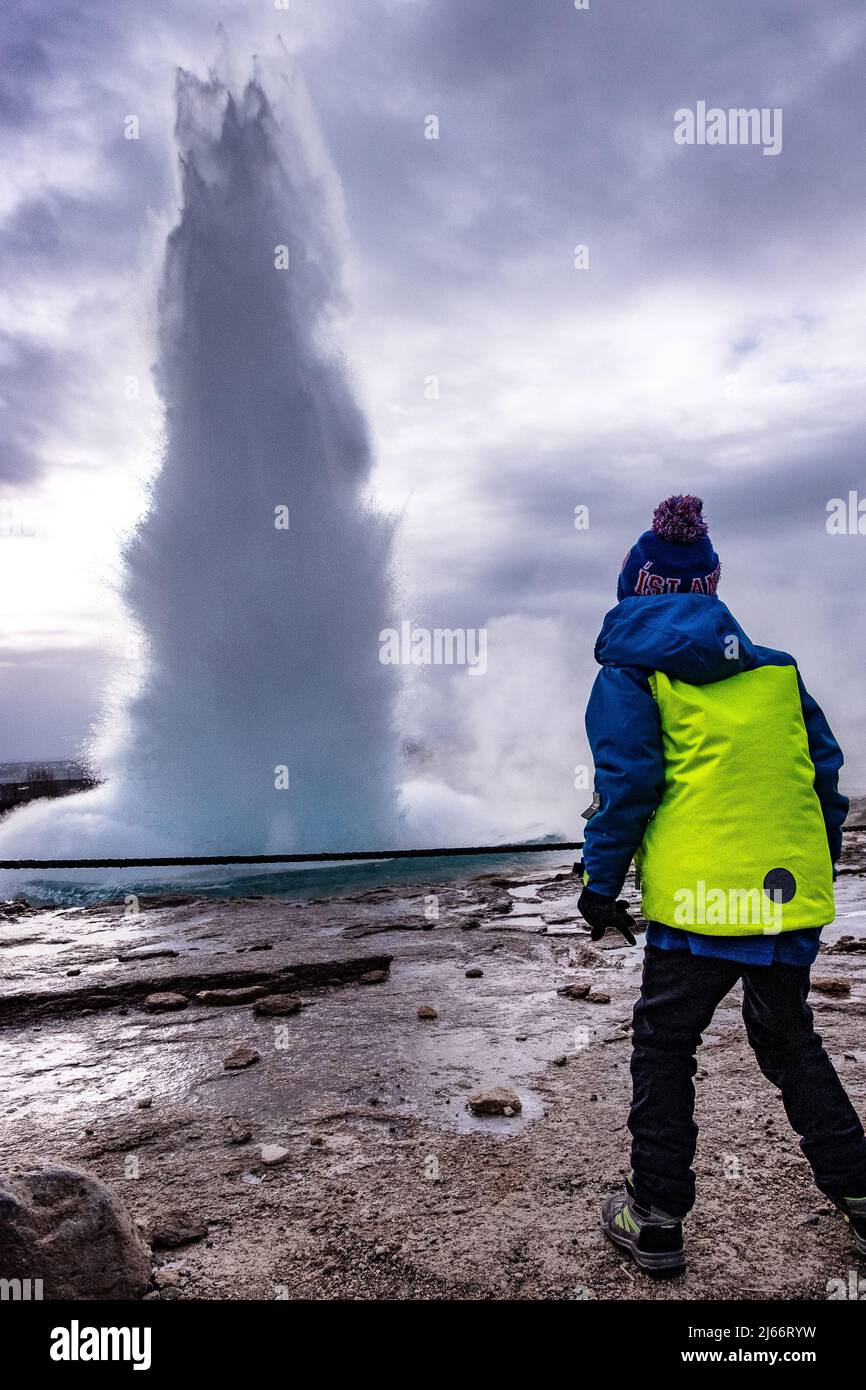 Ein Kind beobachtet den ausbrechenden Geysir 'Trokkur' dans l'île. Island ist ein tolles Reiseziel mit Kindern! Banque D'Images