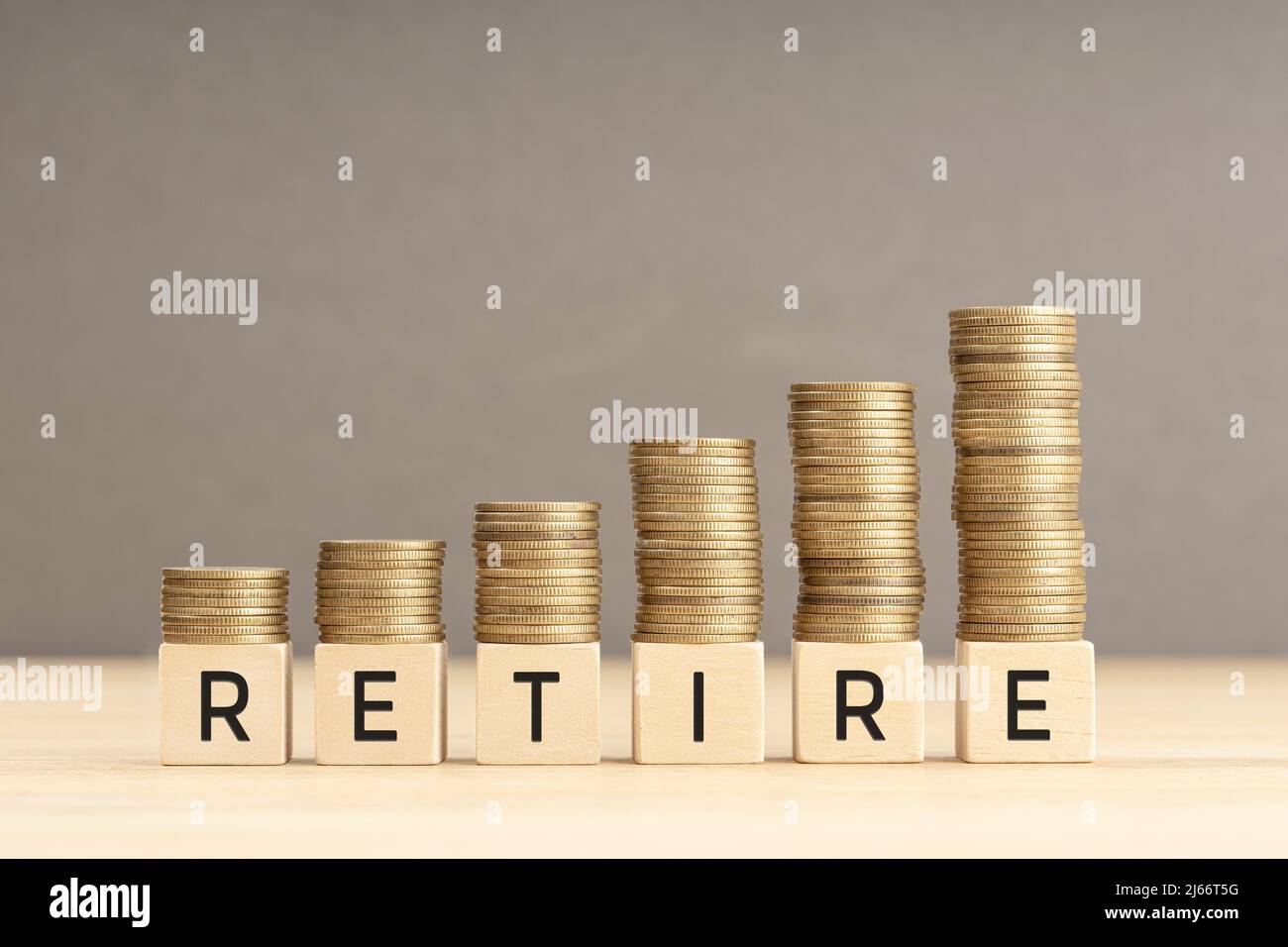 Retirez le mot en blocs de bois avec des pièces empilées dans des piles croissantes. Concept de retraite dans la richesse. Copier l'espace Banque D'Images