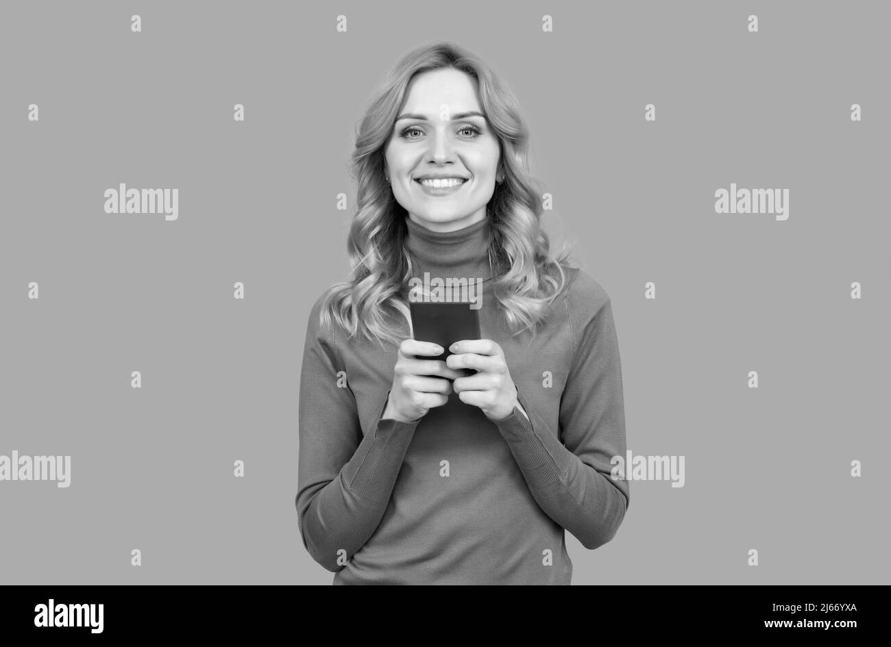 Happy Woman chat messages en ligne sur smartphone communication mobile fond gris, chat Banque D'Images