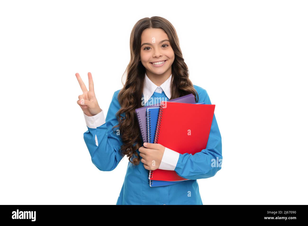 portrait d'enfant heureux avec cahier d'école isolé sur le geste de paix de spectacle blanc, lycée. Banque D'Images