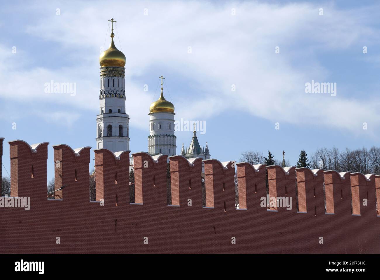 Ivan la Grande Tour de la cloche avec des coupoles d'or derrière le mur de brique rouge du Kremlin le jour ensoleillé Banque D'Images