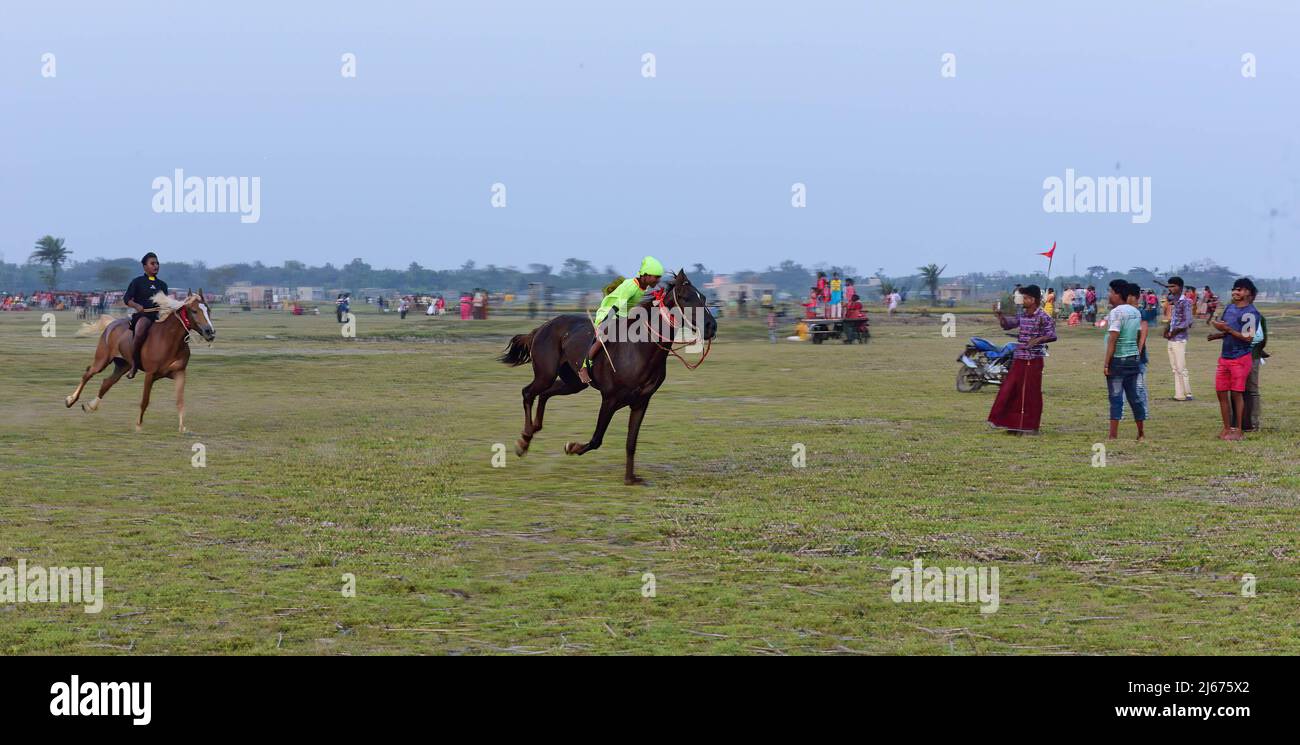 De jeunes jockeys sont à cheval lors d'une course de chevaux en milieu rural. Après les saisons de récolte, les courses de chevaux sont organisées dans ces champs chaque année. Les jockeys qui sont des enfants sont des chevaux sans équipement de protection ou de sécurité. Banque D'Images