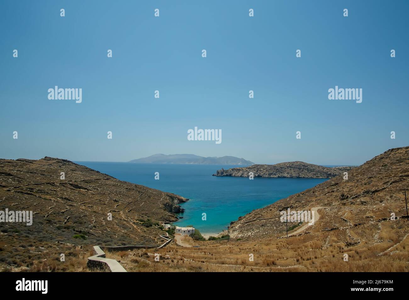 Vue panoramique sur la plage de Valmas, et un phare au loin sur l'île d'iOS en Grèce Banque D'Images