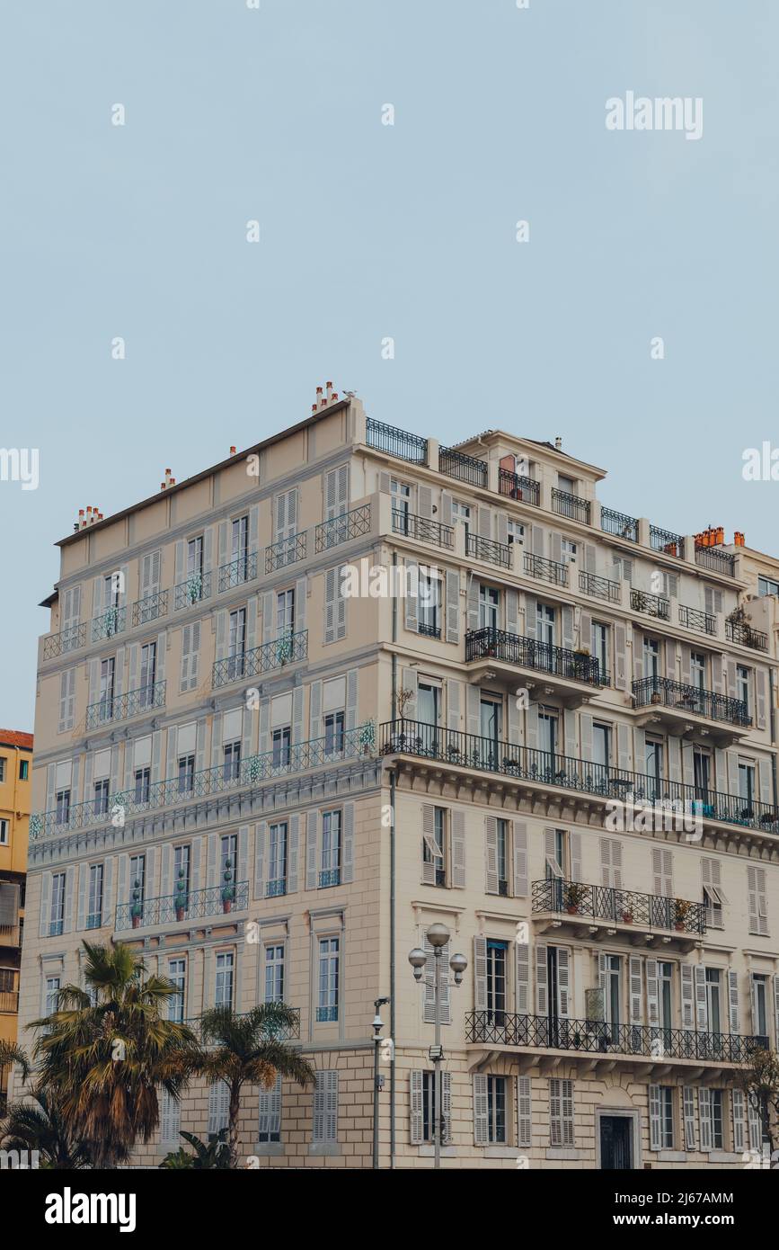 Immeuble résidentiel avec les fenêtres peintes sur un mur latéral à Nice, en France, contre le ciel bleu. Banque D'Images