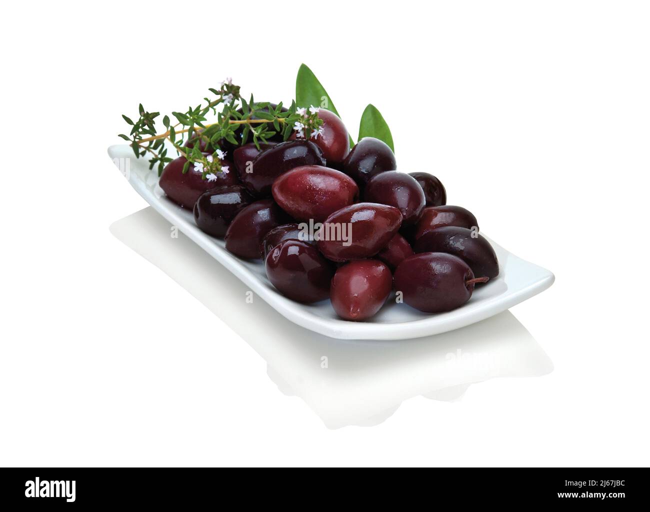 Olives noires Kalamata dans une assiette moderne blanche avec deux feuilles d'olive et du thym Banque D'Images