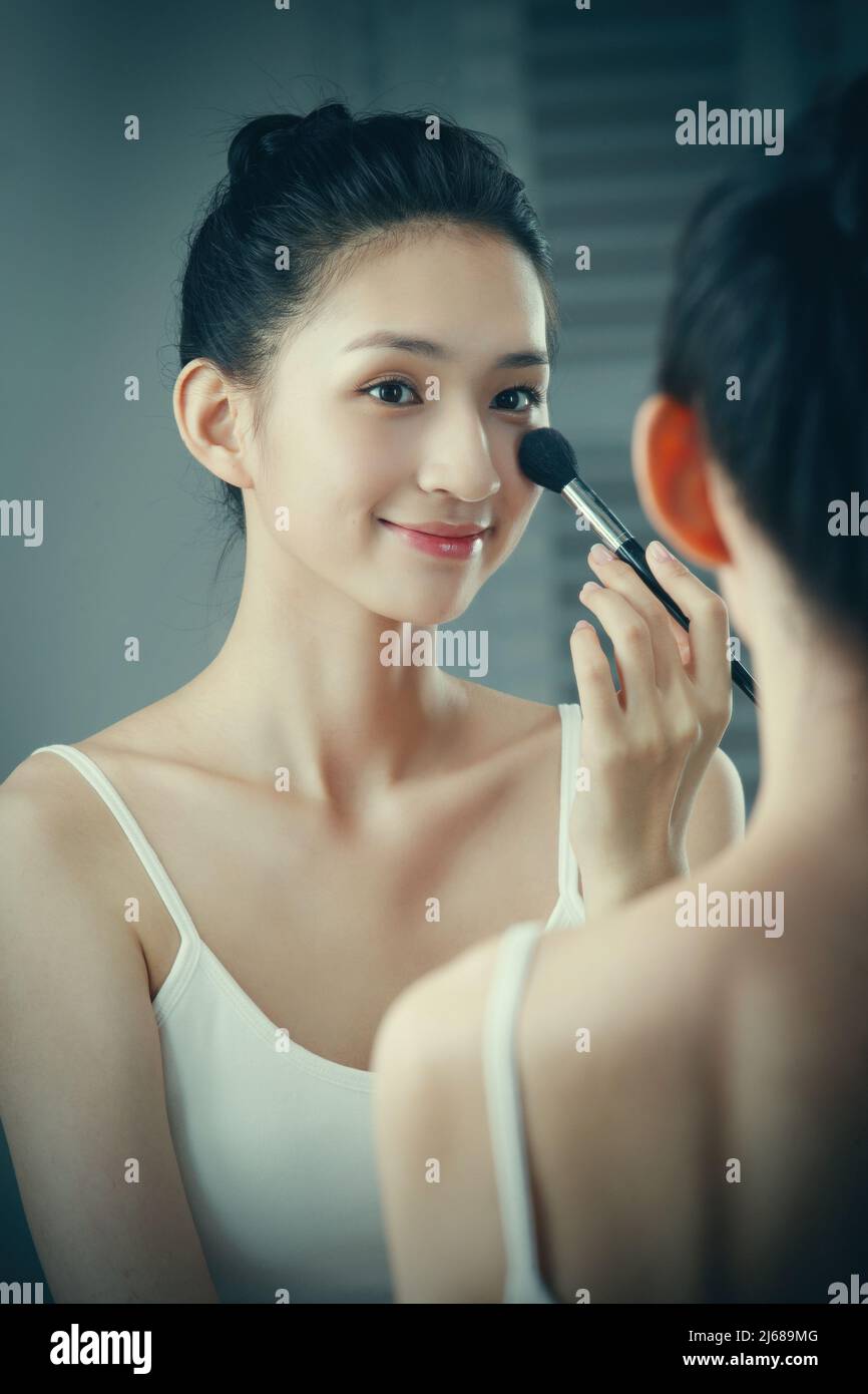 La jeune femme dans le maquillage de miroir Banque D'Images