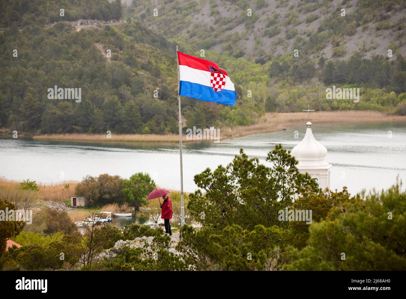 Skradin petite ville du comté de Šibenik-Knin en Croatie, rivière Krka et clocher de l'église de Mala Gospa et drapeau national de la caste Banque D'Images