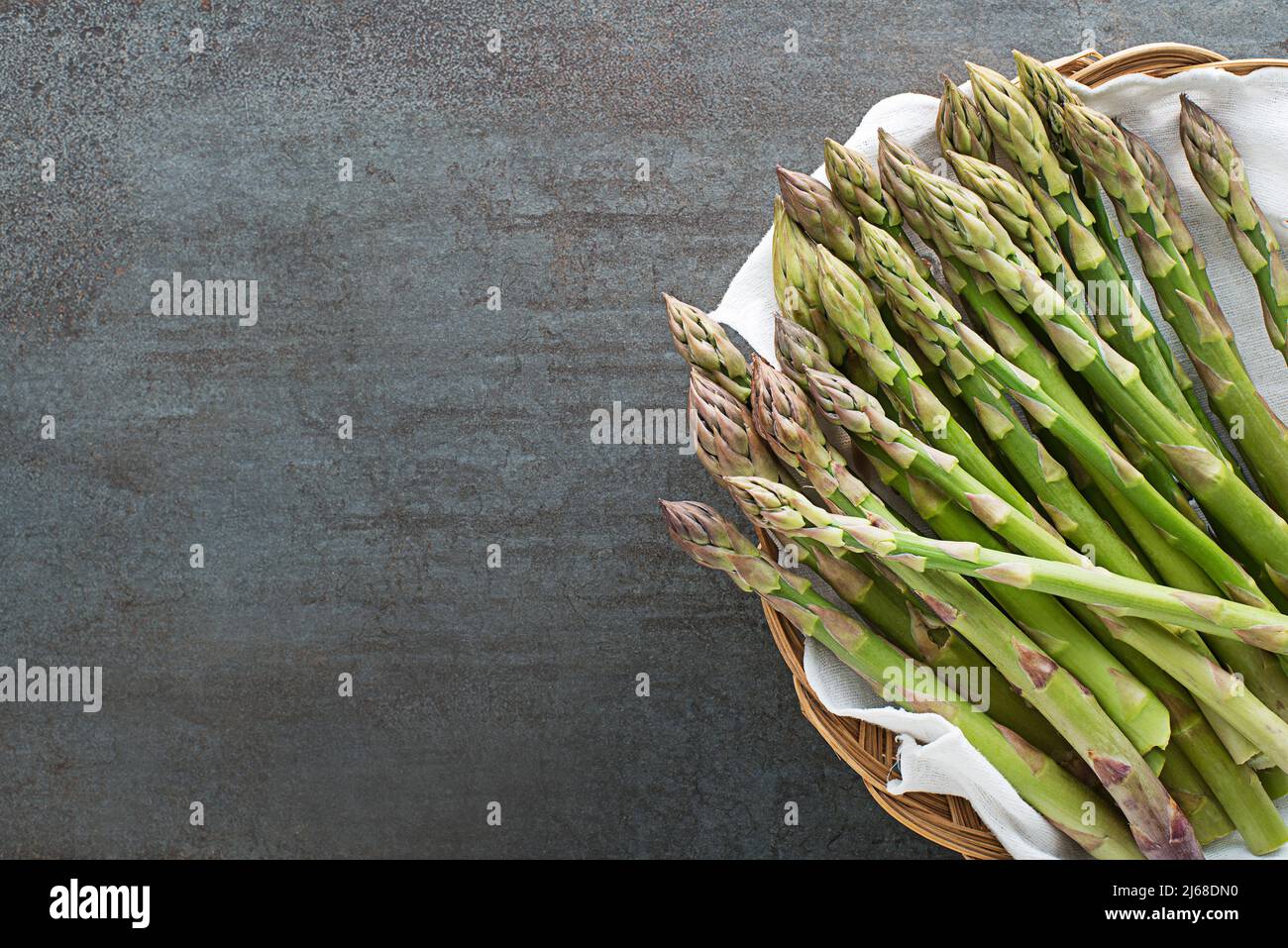 Asperges. Asperges fraîches. Asperges vertes marinées dans un panier. Grappes d'asperges vertes sur la table grise, vue de dessus - image Banque D'Images