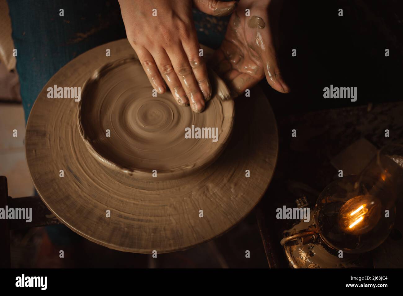 femme fait plaque d'argile dans atelier de poterie, beau fond, atmosphère authentique, style de vie. lampe jaune Banque D'Images