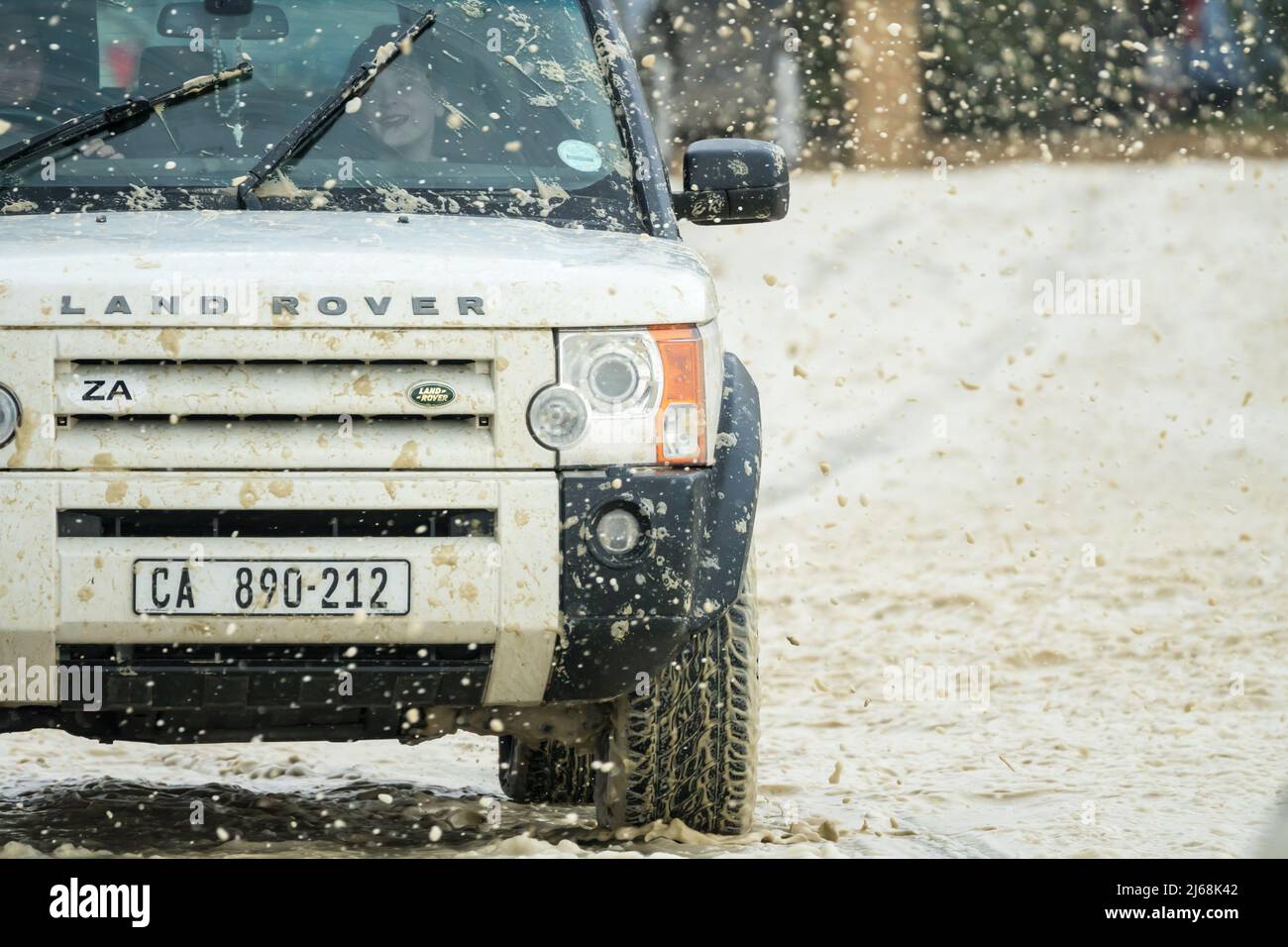 Véhicule Land rover ou véhicule 4x4 de proximité en conduite dans des conditions de vent orageux sur une route côtière recouverte de mousse de mer pendant l'hiver au Cap Banque D'Images