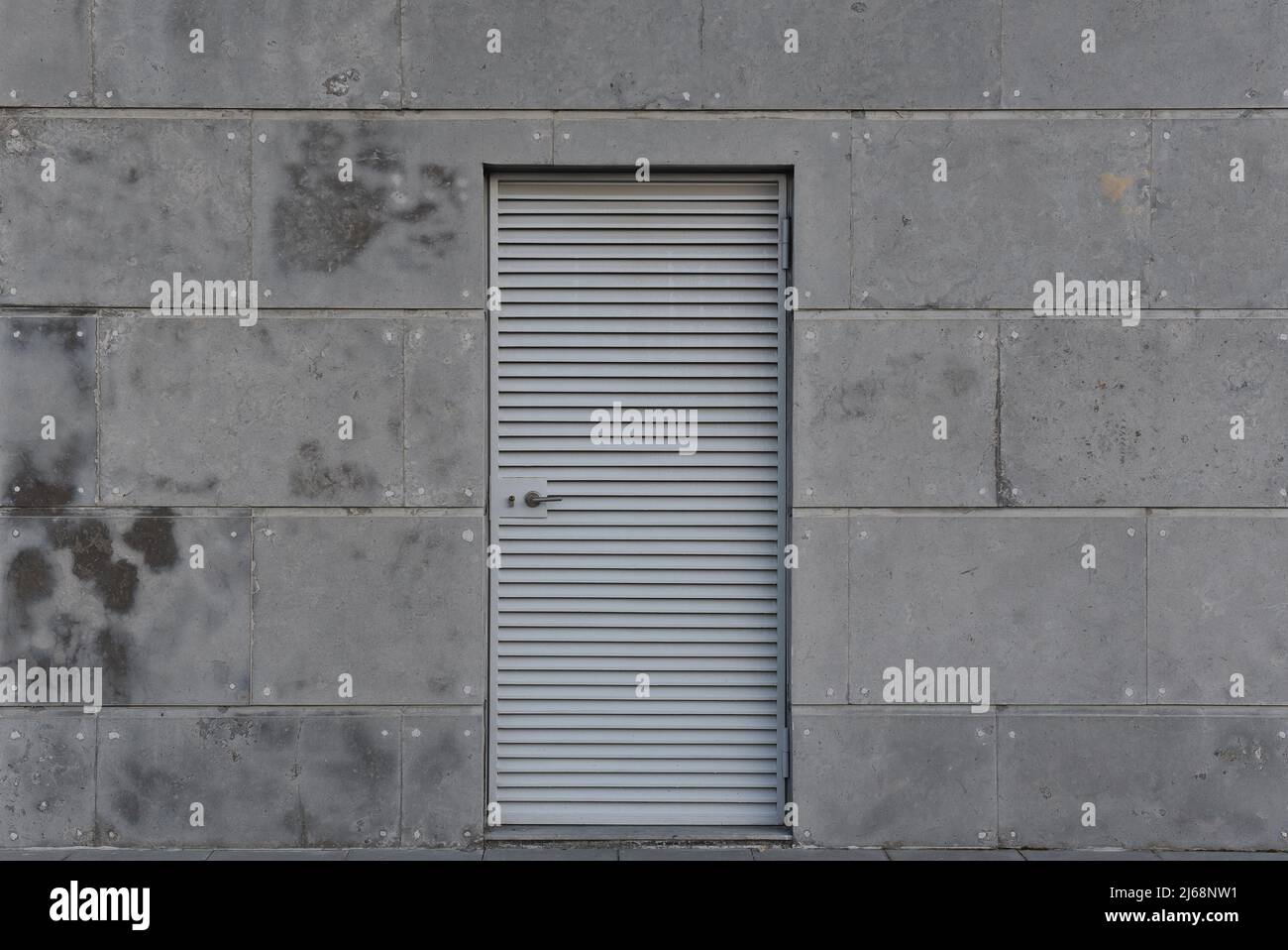 Porte en acier avec volets sur une façade en béton Banque D'Images