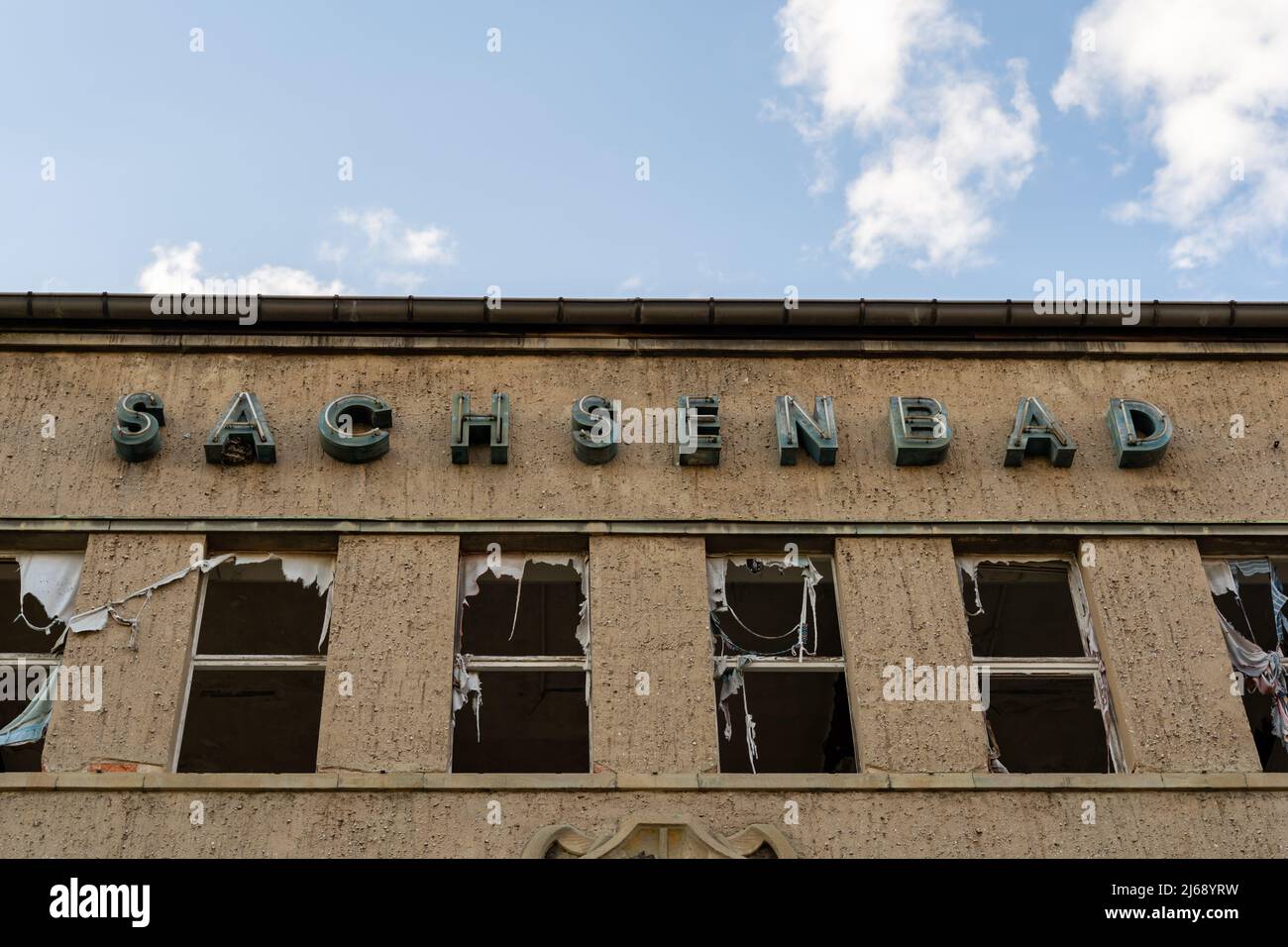 Façade de l'ancien Sachsenbad à Pieschen. Piscine intérieure abandonnée. Célèbre ruine en face d'un ciel bleu avec des nuages. Grandes lettres. Banque D'Images