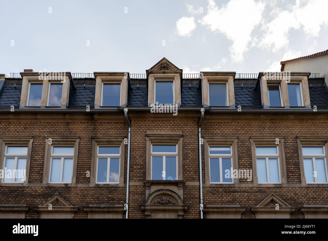 Façade de maison avec de vieilles briques de clinker jaune dans une ville allemande. Vue de face d'un immeuble résidentiel sale et abîmé. Ancienne architecture en Allemagne. Banque D'Images