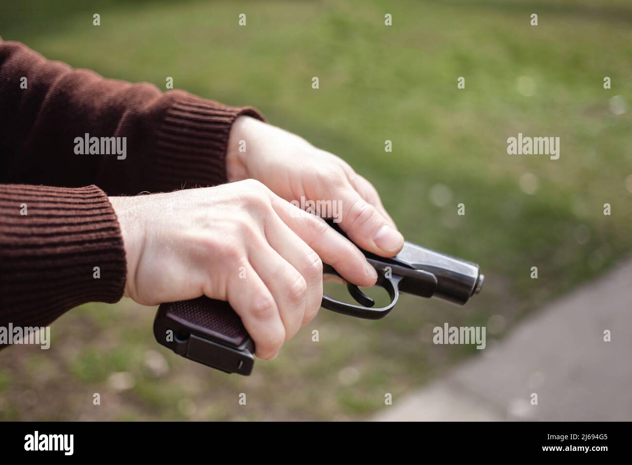 Un jeune homme charge un fusil contre une herbe verte. Armes à feu extérieur. Sport, passe-temps Banque D'Images