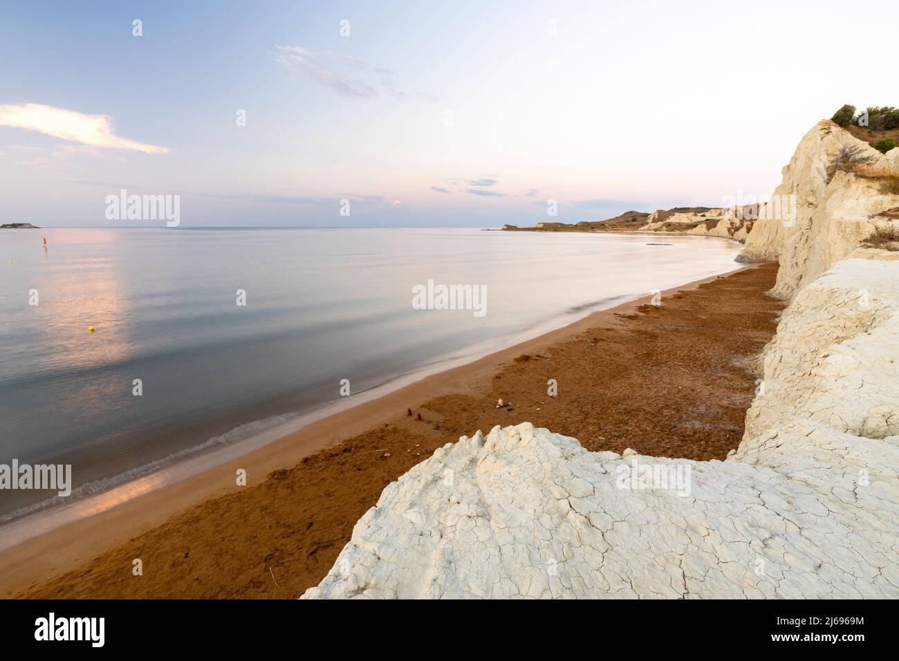 Mer calme à l'aube encadrée par des falaises de calcaire surplombant le sable doré de la plage de Xi, Kefalonia, Iles Ioniennes, Iles grecques, Grèce, Europe Banque D'Images