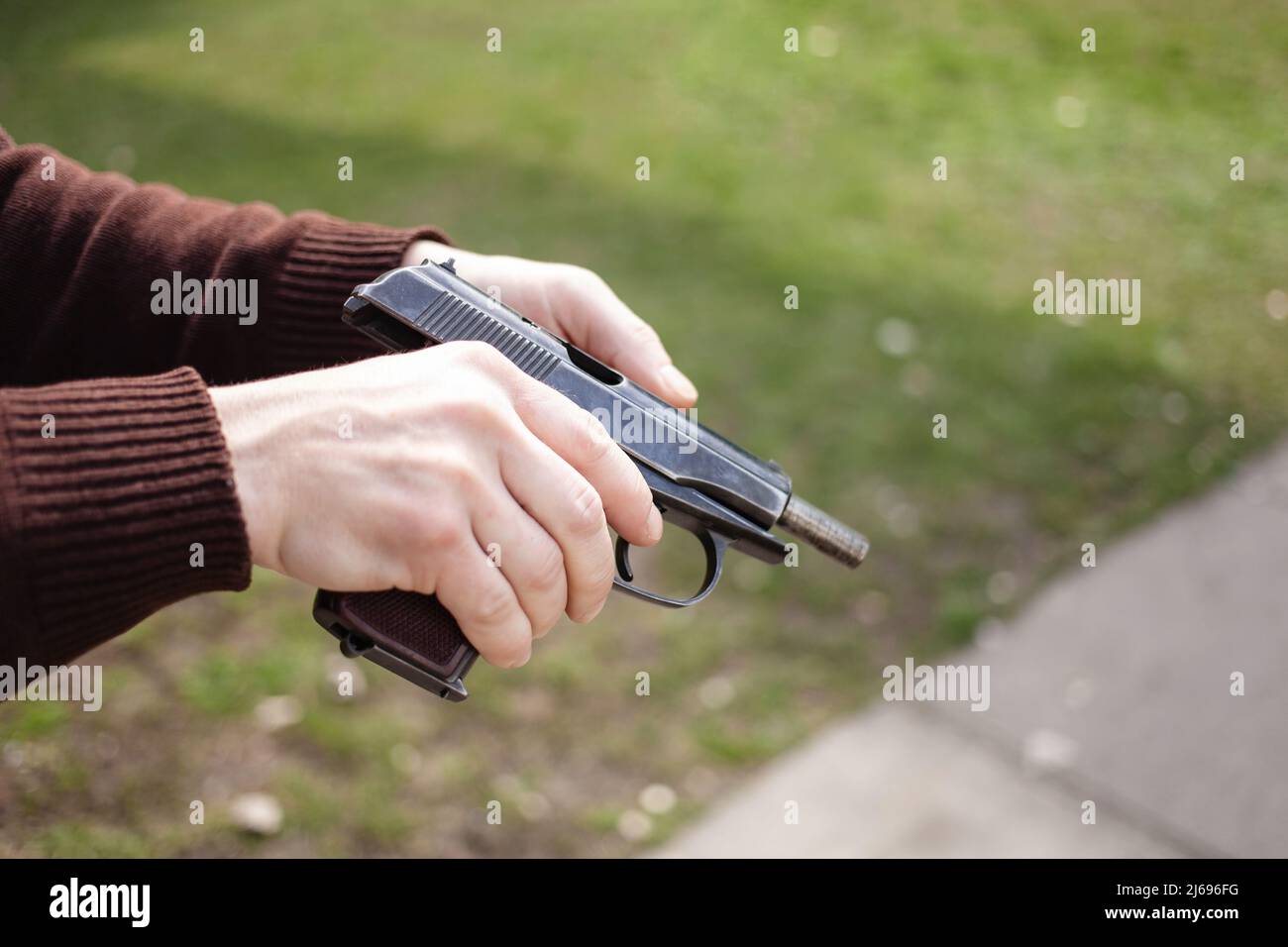 Un jeune homme charge un fusil contre une herbe verte. Armes à feu extérieur. Sport, hobbies gros plan Banque D'Images