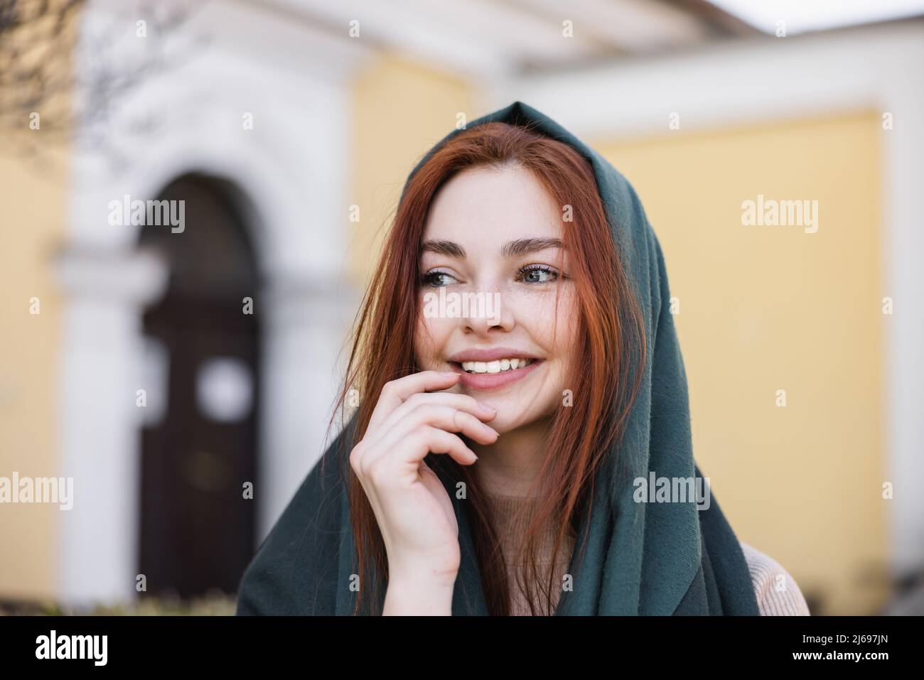 portrait d'une jeune femme joyeuse en foulard souriant tout en regardant loin Banque D'Images