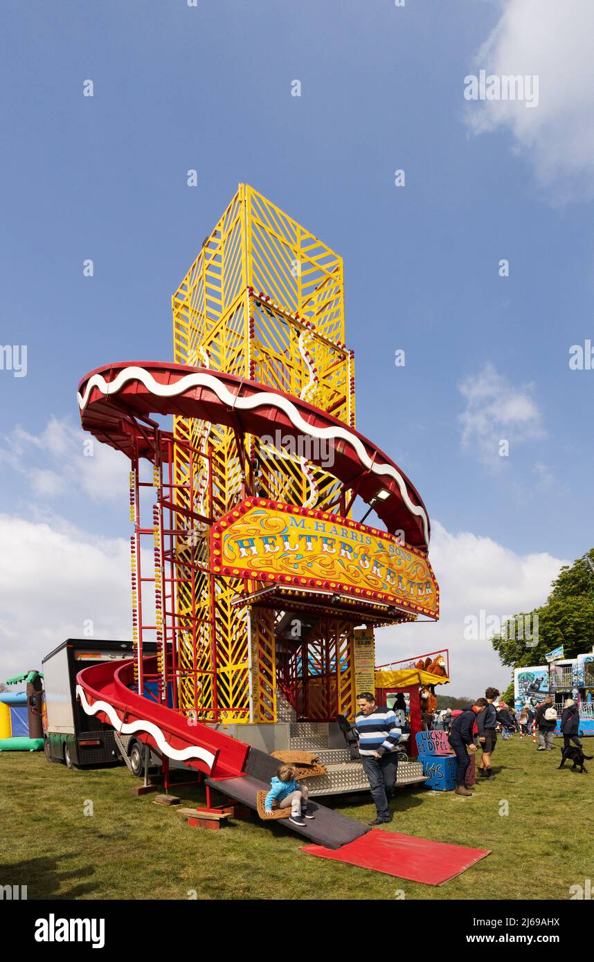 Tour de Helter Skelter ; un enfant descend un tour de foire de Helter Skelter lors d'une journée de printemps ensoleillée, à l'East Anglian Game & Country Fair, Suffolk, Royaume-Uni Banque D'Images