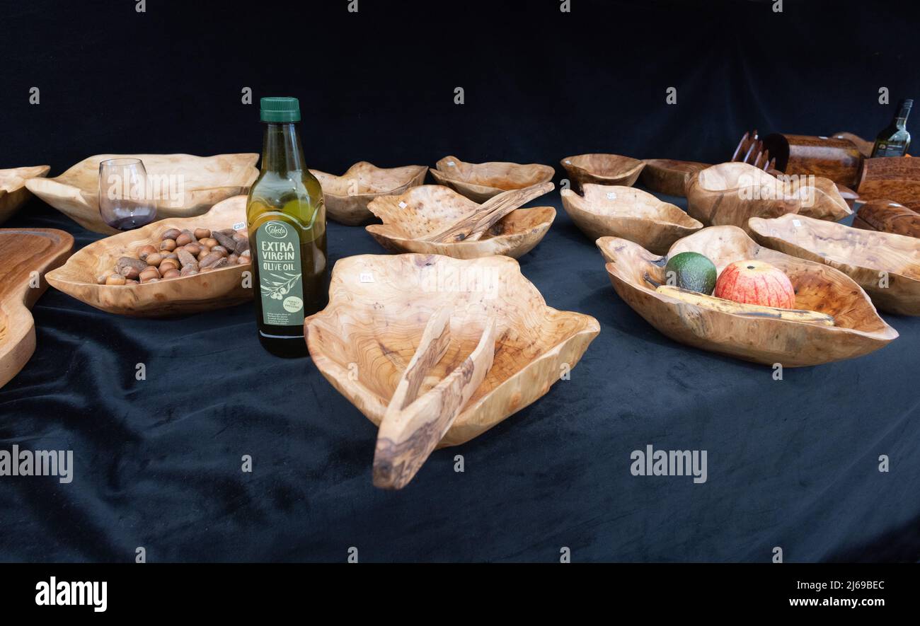 Sculpture et bols en bois d'olive, plats sur une cabine artisanale avec une bouteille d'huile d'olive, Suffolk UK Banque D'Images