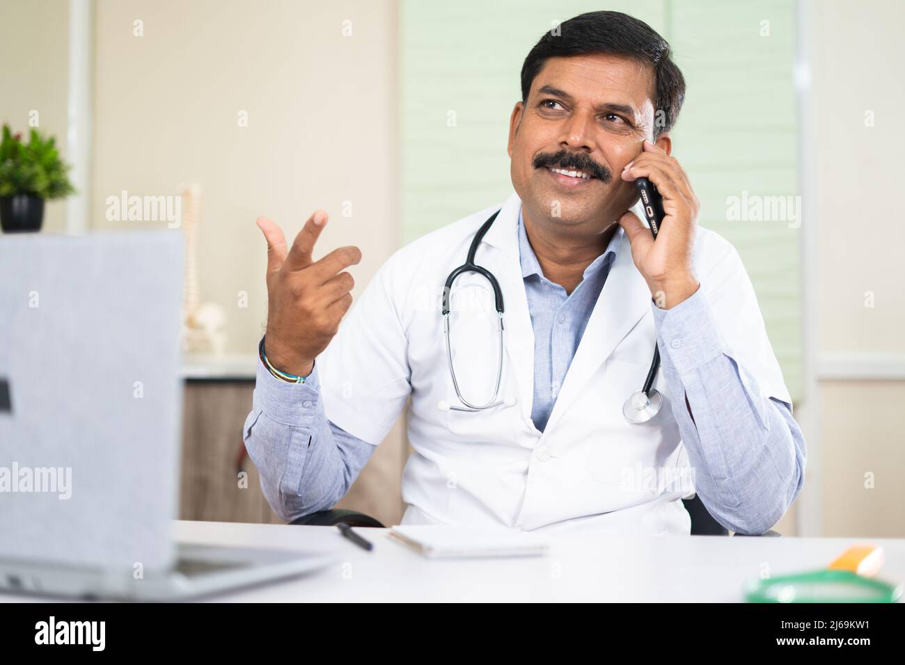 joyeux sourire médecin occupé à parler avec le patient sur appel de téléphone mobile - concept de communication, de soutien et de consultation Banque D'Images