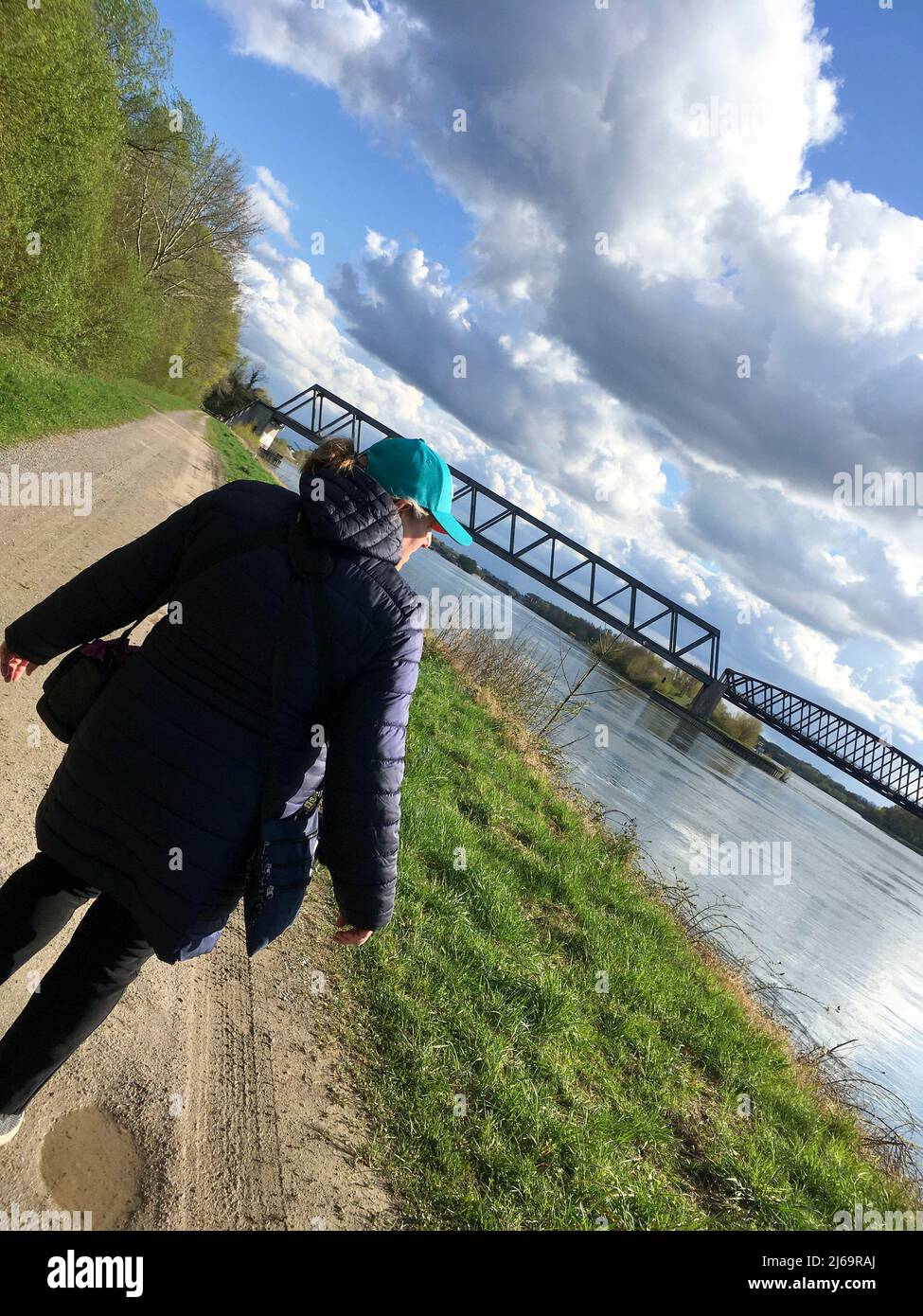 Frau spaziert, am Rhein entlang, vor ihr die Brücke von Winterdorf über den Rhein nach Frankreich Banque D'Images