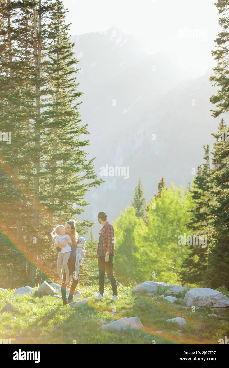 Sunflare sur la famille avec des pins et des montagnes Banque D'Images