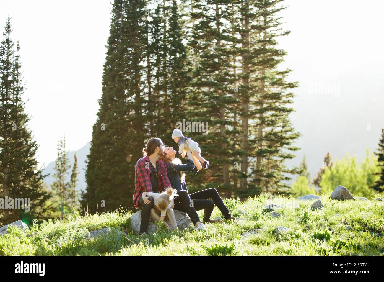 Famille regardant bébé assis sur des rochers dans Big Cottonwood Canyon Banque D'Images
