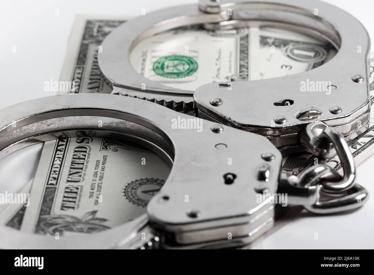 Les menottes de police reposent sur des billets en dollars. Crime, justice et argent. Crime et corruption concept avec menottes. Banque D'Images