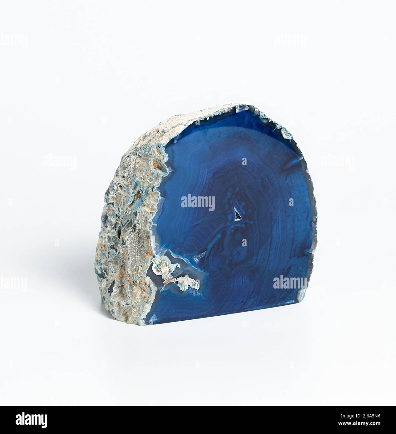 Section transversale cristalline bleu agate étonnante isolée sur fond blanc. Surface en cristal d'agate translucide naturel, bleu, coupe abstraite de pierre dense Banque D'Images