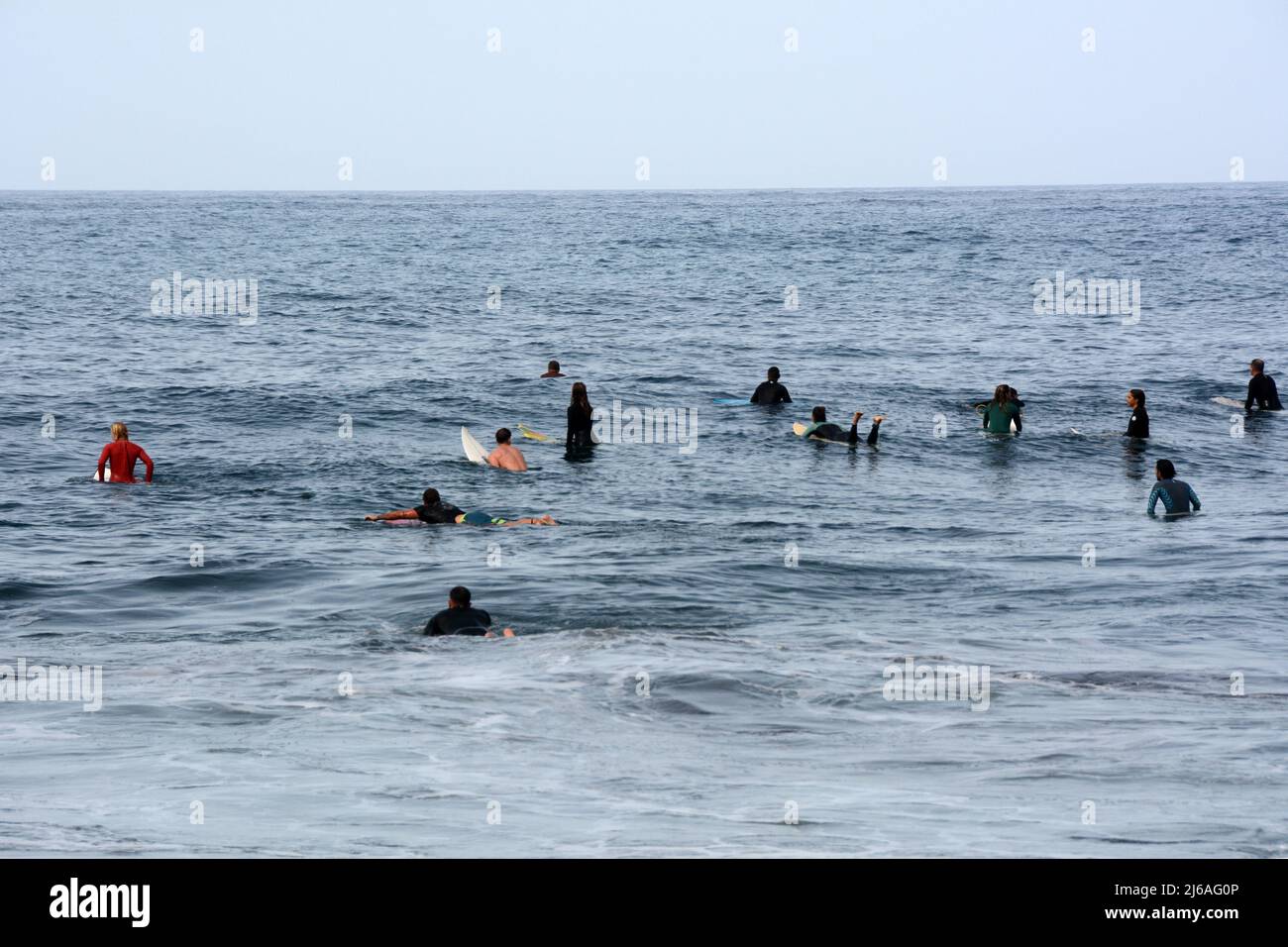Un groupe de surfeurs attendant dans l'eau calme pour les vagues à la plage Playa del Socorro à Los Realejos, sur la côte nord de Ténérife, îles Canaries, Espagne. Banque D'Images