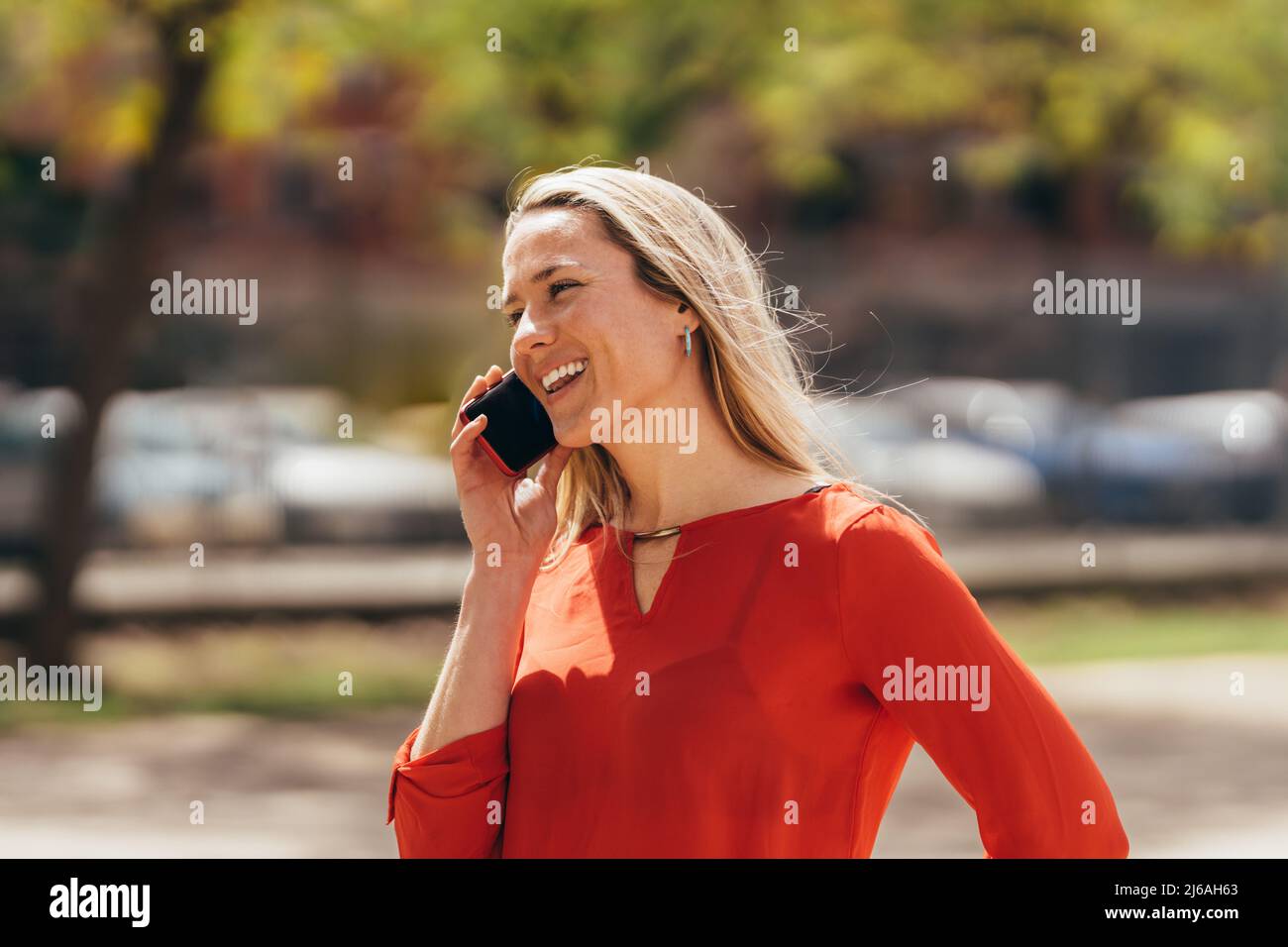 Bonne jeune femme caucasienne parlant au téléphone portable Banque D'Images